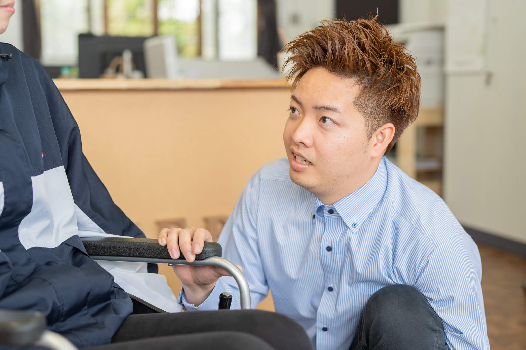 車椅子の人をサポートしている男性