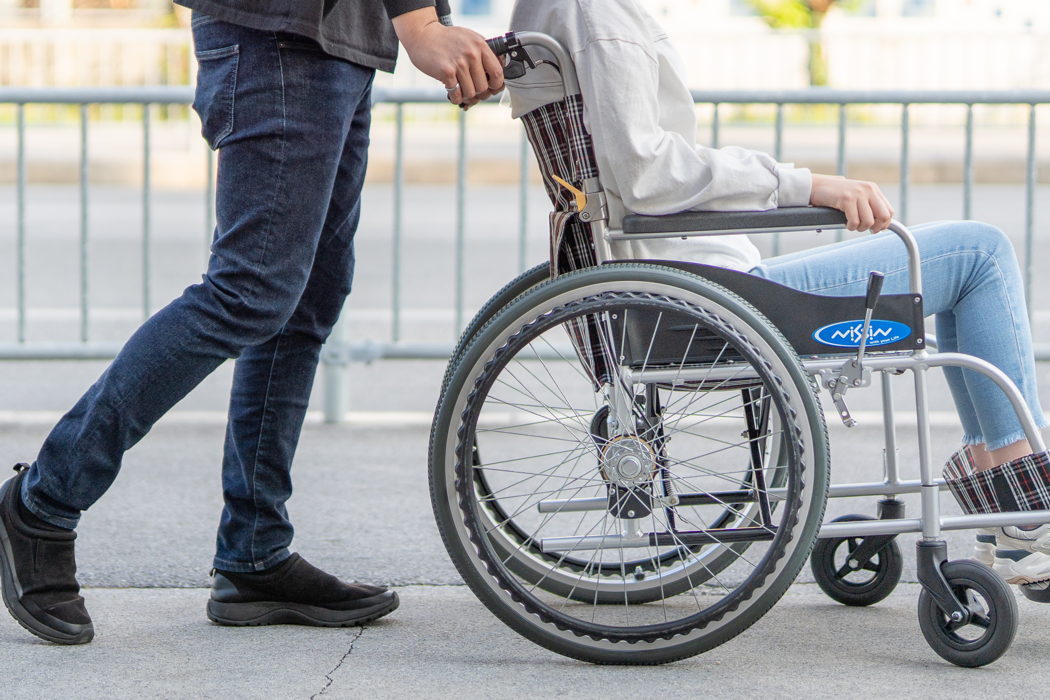 車椅子に乗っている人と、後ろから押している介助者